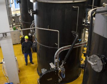 Engineer from TripleNine standing next to Bio-Aqua's fish protein and oil recovery system.